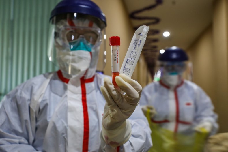This photo taken on February 4 shows a medical staff member holding a test tube after taking samples taken from a person to be tested for the new coronavirus at a quarantine zone in Wuhan, then the epicenter of the outbreak, in China's central Hubei 