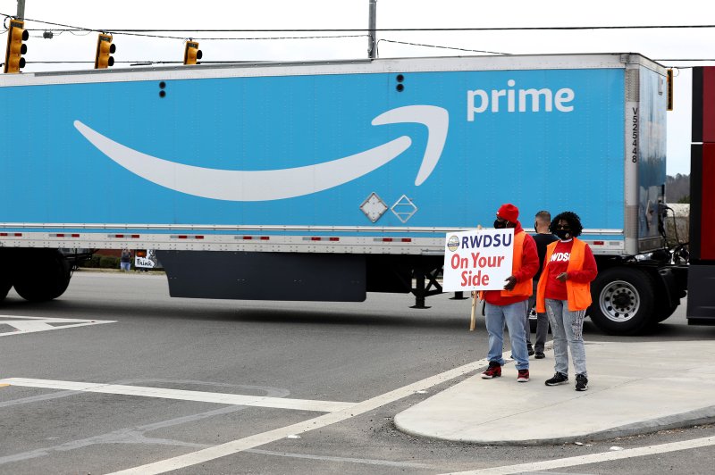 People hold a banner at the Amazon facility as members of a congressional delegation arrive to show their support for workers who will vote on whether to unionize, in Bessemer, Alabama, U.S. March 5, 2021. Dustin Chambers—Reuters