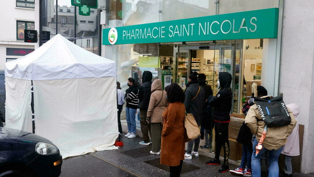 People queue for Covid-19 tests in front of a testing booth outside a pharmacy in Nantes, France, on January 8, 2022. © Stephane Mahe, Reuters