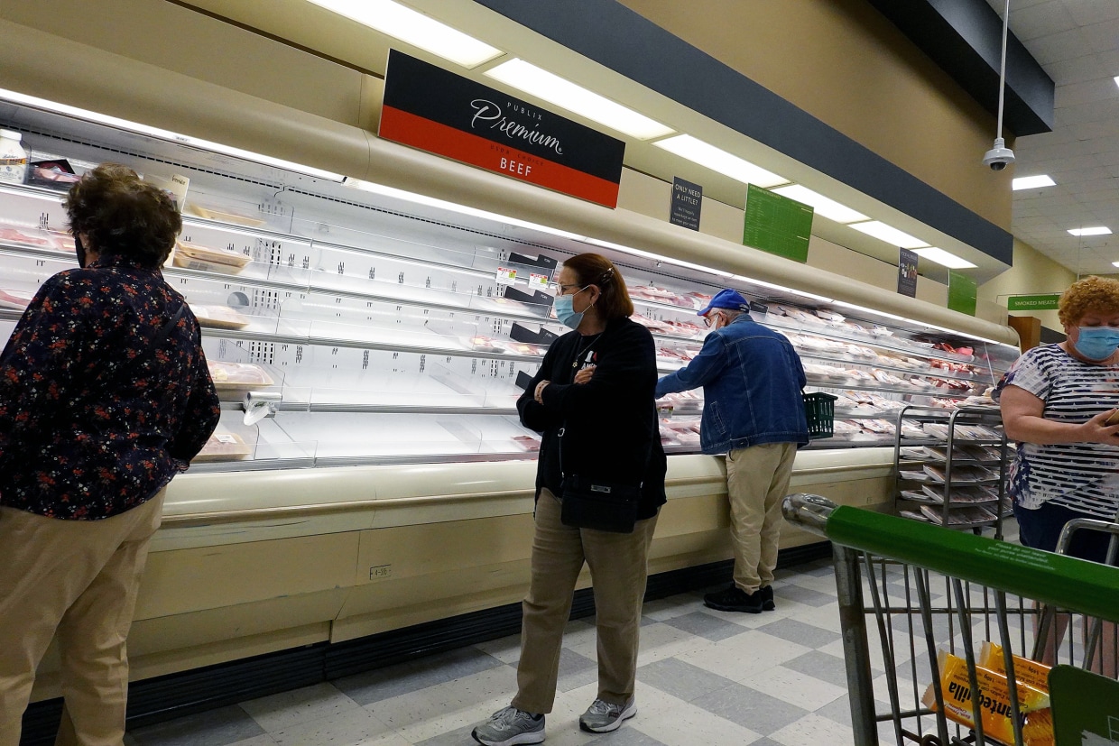 A shopper walks past empty meat shelves in a supermarket in Miami, on Jan. 11, 2022.Joe Raedle / Getty Images