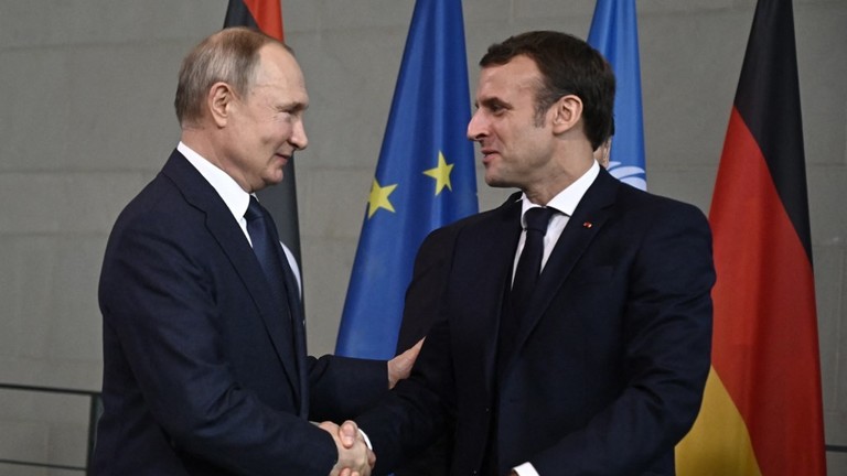 Vladimir Putin (L) and Emmanuel Macron shake hands during the peace summit on Libya at the Chancellery in Berlin, Germany, January 19, 2020 © AFP/ Tobias Schwarz