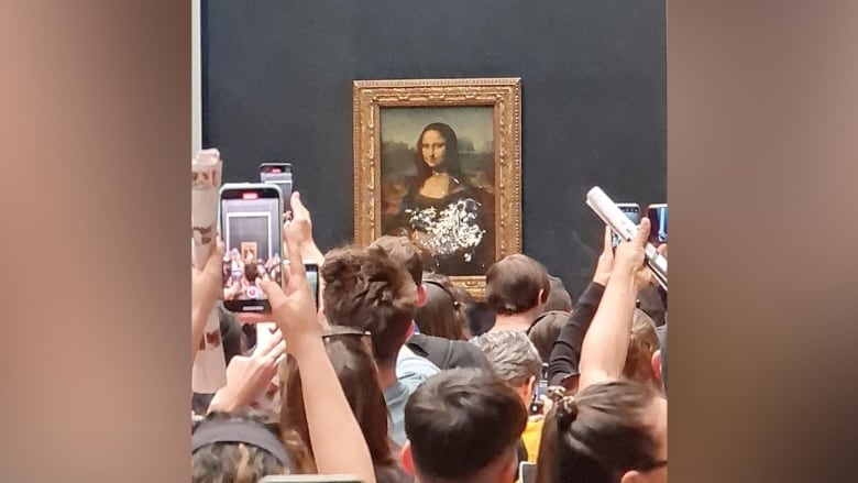 Glass protecting the Mona Lisa at the Louvre in Paris is seen smeared with cake on May 29, 2022, in this image taken from social media. (@klevisl007/Twitter/Reuters)