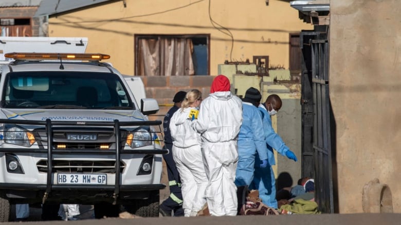 Police and forensic workers inspect the scene of a mass shooting in Soweto, South Africa, on Sunday. (Ihsaan Haffejee/AFP/Getty Images)