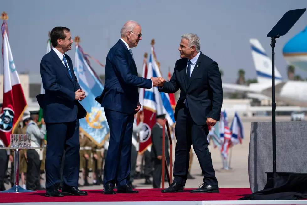 Israeli President Isaac Herzog, left, looks on as President Joe Biden gives a fist bump to Israeli Prime Minister Yair Lapid during an arrival ceremony after arriving at Ben Gurion Airport, Wednesday, July 13, 2022, in Tel Aviv.