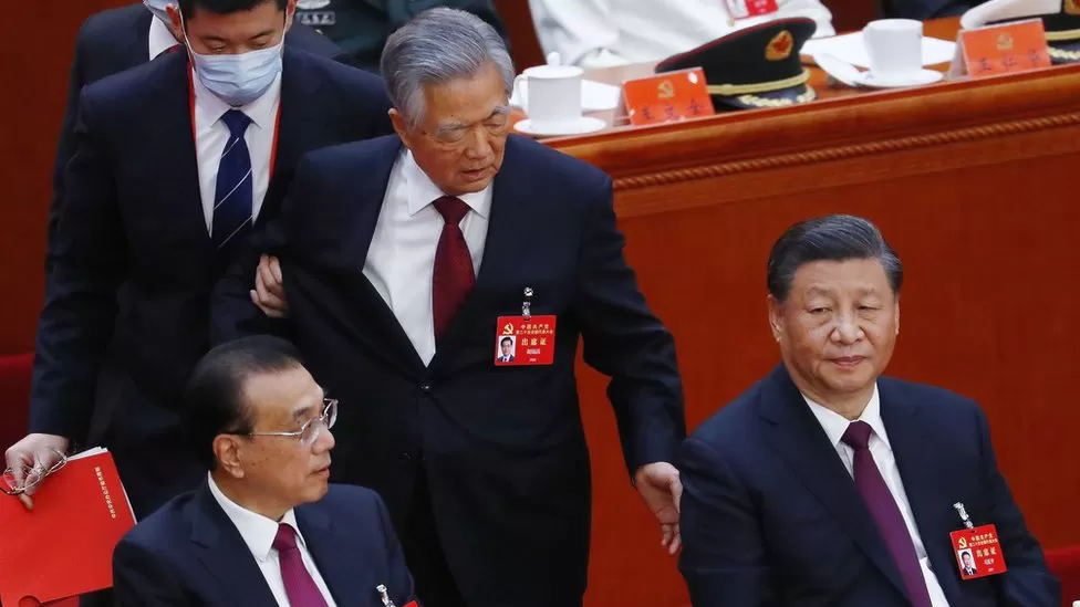 EPA / Hu Jintao (centre) was sitting next to his successor Xi Jinping (right) before being escorted out