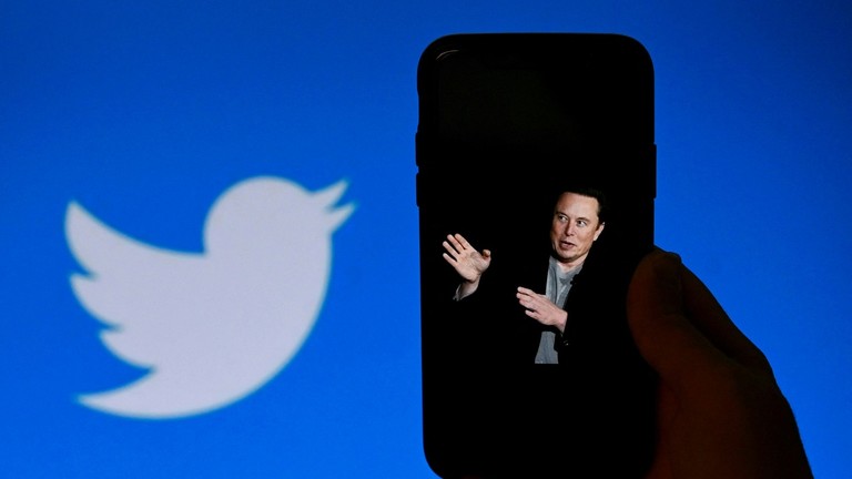 FILE PHOTO: A phone screen displays a photo of Elon Musk with the Twitter logo shown in the background. ©  AFP / Olivier Douliery