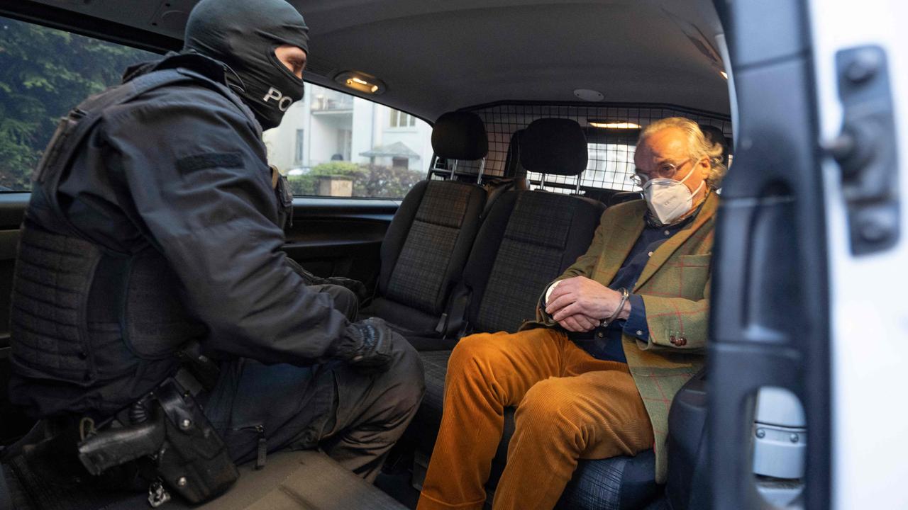 German special police forces detain Heinrich XIII Prinz Reuss in a police car after searching a house in Frankfurt. (Photo by Boris Roessler / dpa / AFP)