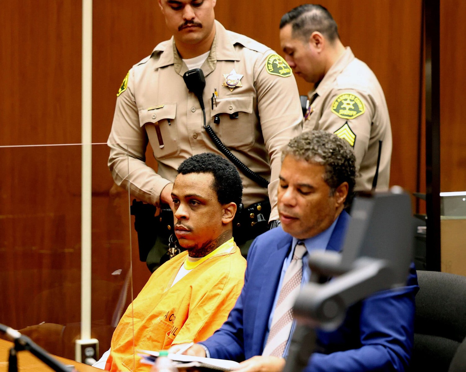Eric R. Holder Jr., left, was found guilty of first-degree murder last year, more than three years after fatally shooting the Los Angeles rapper Nipsey Hussle.Credit...Pool photo by Frederick M. Brown