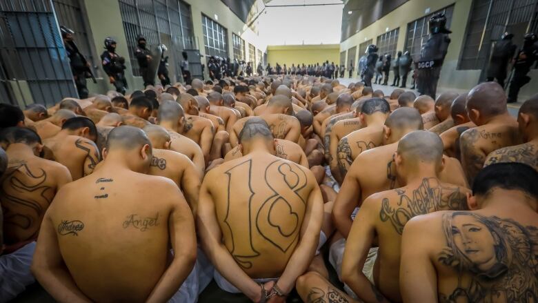 Inmates wait to be taken to their cells after 2,000 men were transferred to the Terrorism Confinement Center, El Salvador's new mega prison. (Secretaria de Prensa de la Presidencia/Reuters)