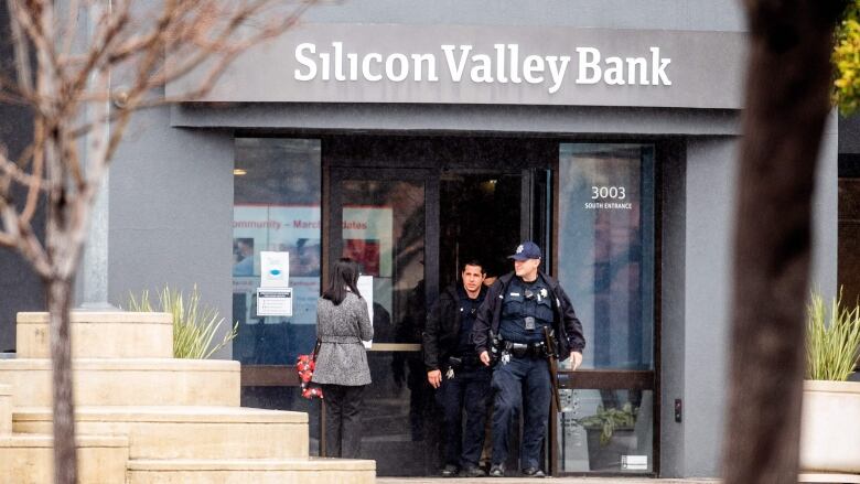 Police officers leave the headquarters of Silicon Valley Bank in Santa Clara, Calif., on Friday. U.S. authorities swooped in and seized the assets of the bank after a run on deposits this week. (Noah Berger/AFP/Getty Images)