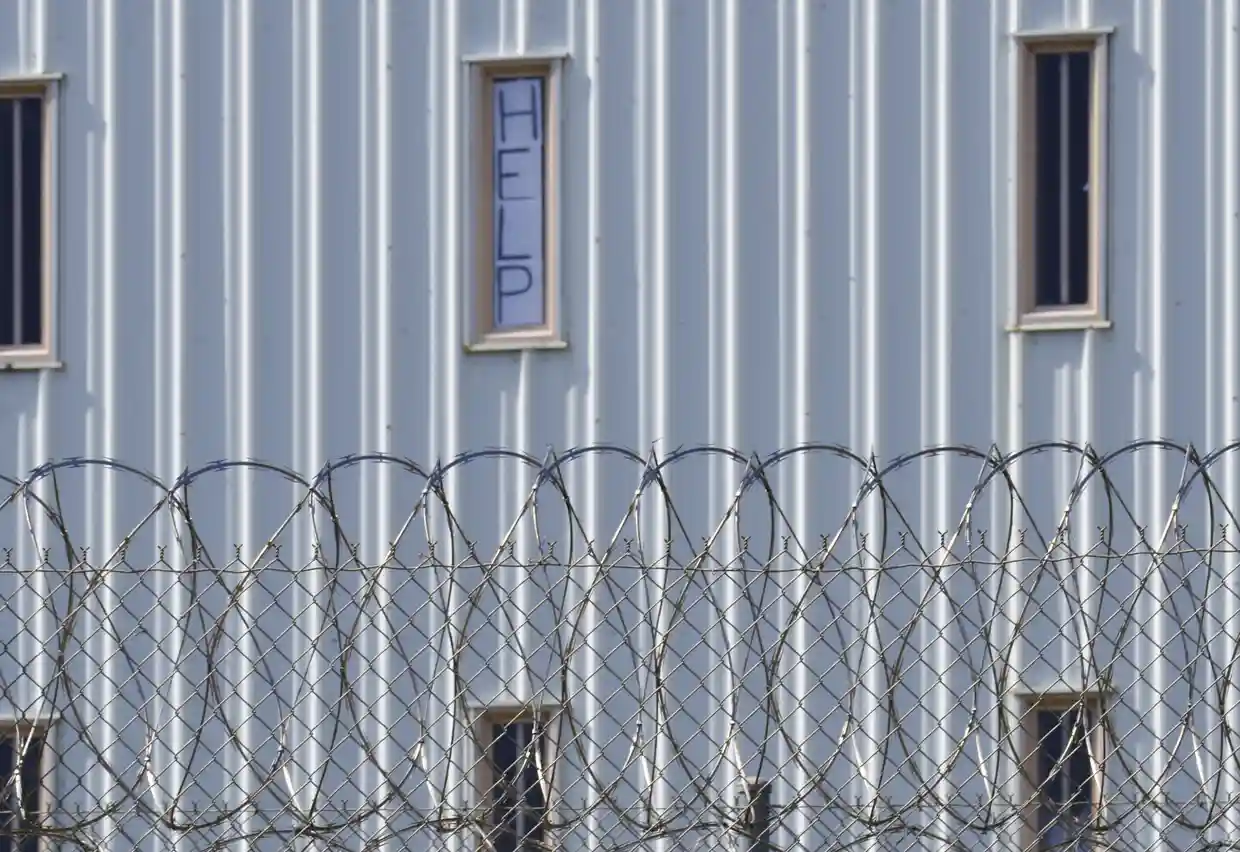 A ‘help’ sign is posted in the window of a correctional facility in Atmore, Alabama. Photograph: Kim Chandler/AP