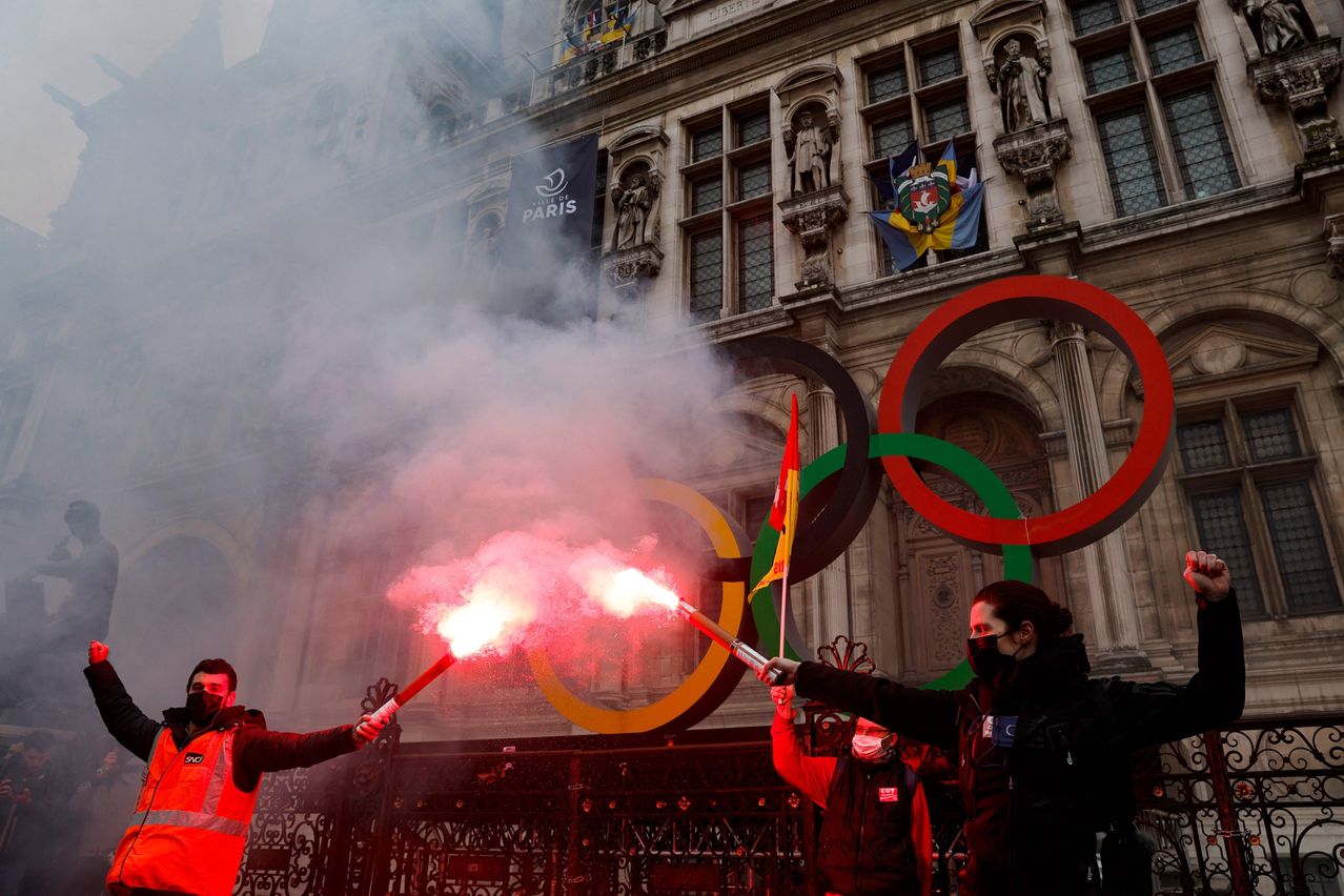 Protestors light red flares in front of the Olympic Rings at the Hotel De Ville in Paris. GEOFFROY VAN DER HASSELT/AGENCE FRANCE-PRESSE/GETTY IMAGES