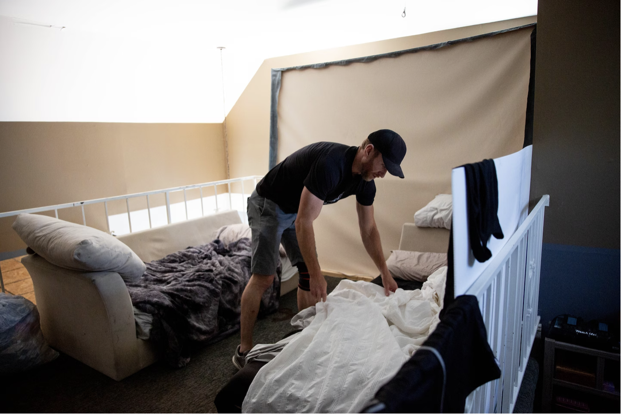  Josh Hooks tidies some makeshift beds at his home in Los Angeles. (Allison Zaucha for The Washington Post)