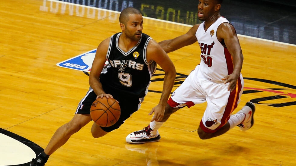 Tony Parker, playing for the San Antonio Spurs, drives towards the basket against the Miami Heat’s Norris Cole during the 2014 NBA Finals in Miami, Florida on June 12, 2014. © Chris Trotman, Getty Images via AFP
