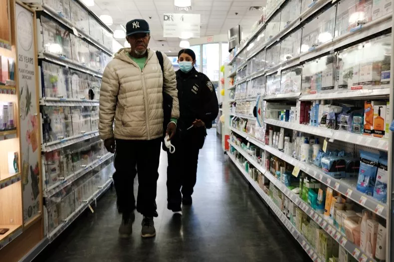 A man is escorted out of a drugstore by a police officer on October 26, 2021, in New York City. The National Retail Federation estimated the total cost of shrink in the United States to be $94.5 billion in 2021. SPENCER PLATT/GETTY IMAGES