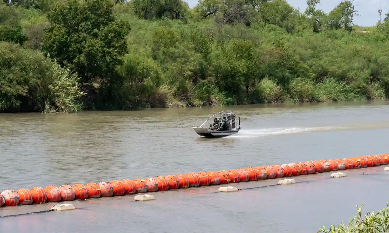 A border patrol boat navigates alongside a string of buoys in the Rio Grande in Eagle Pass, Texas. Photograph: Suzanne Cordeiro/AFP/Getty Images