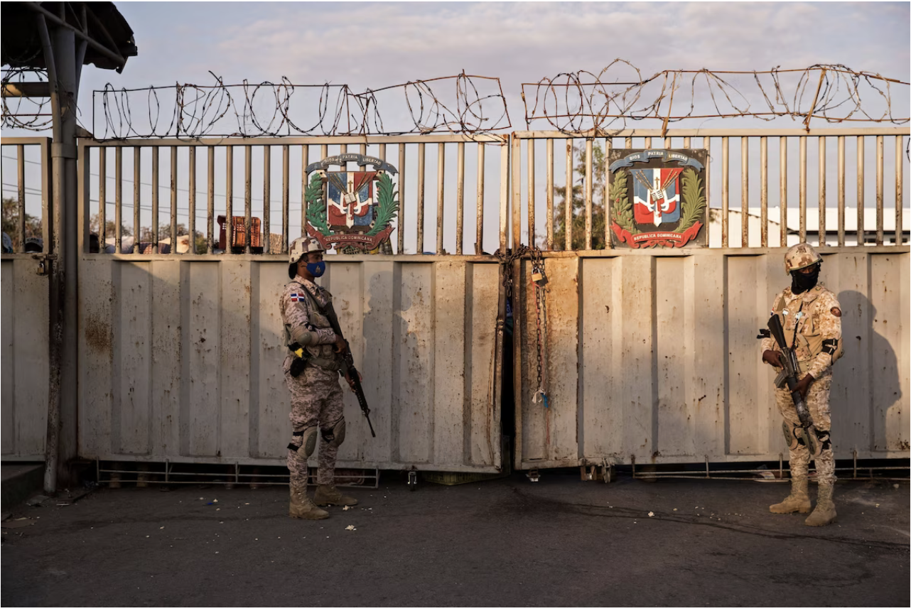  Dominican troops stand guard at a gate in Dajabon in March. (Erika Santelices/AFP/Getty Images)