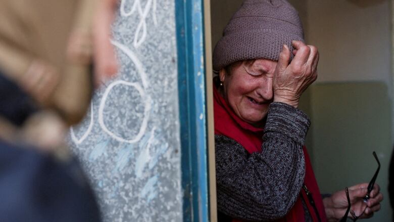 A resident cries as she is encouraged to evacuate her home, near the frontline in Donetsk, on April 2. Civilian casualties have surpassed 26,000 in Ukraine, including more than 9,500 who were killed. (Violeta Santos Moura/Reuters )