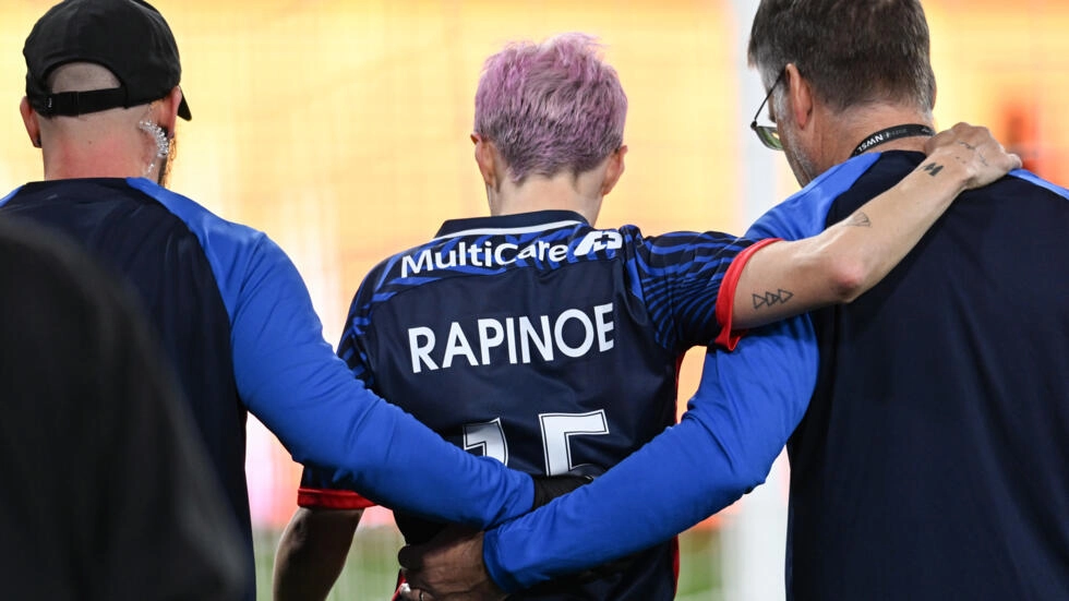 OL Reign's US midfielder Megan Rapinoe is helped off the pitch after sustaining an injury in the opening minutes of the NWSL title match, the final match of her professional football career. © Robyn Beck, AFP