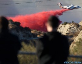 Residents watch fire retardant dropped on an area of the Rye Canyon Fire, one of several fires burning in Southern California.
