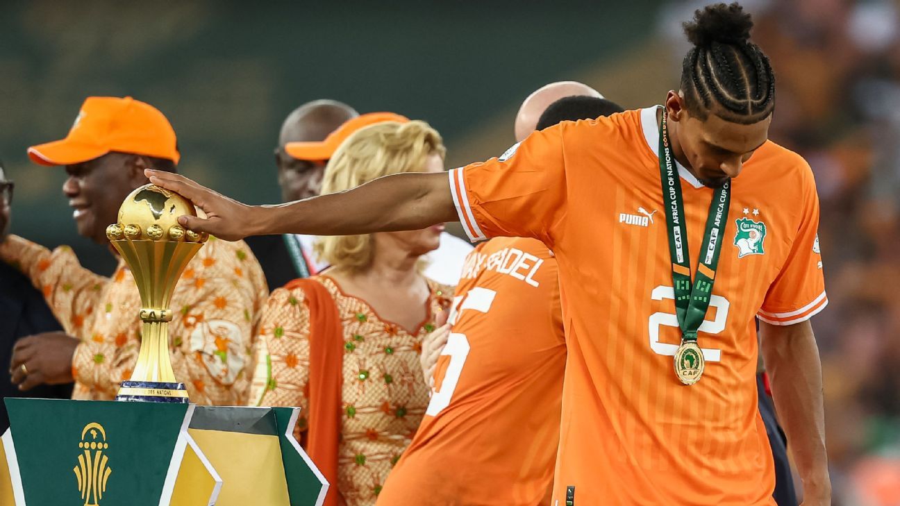 Sebastien Haller reverently touches the Africa Cup of Nations trophy after leading Ivory Coast to the title, less than two years after a testicular cancer diagnosis and a string of recent injuries. FRANCK FIFE/AFP via Getty Images